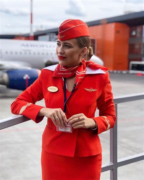 A Woman In An Air Hostess Uniform Standing On The Tarmac