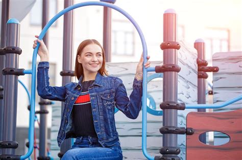 a cute girl is sitting on playground happy caucasian girl in blue