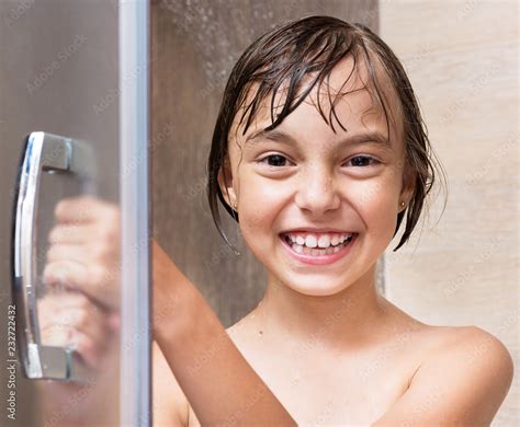 cheerful beautiful girl bathing under a shower at home happy little