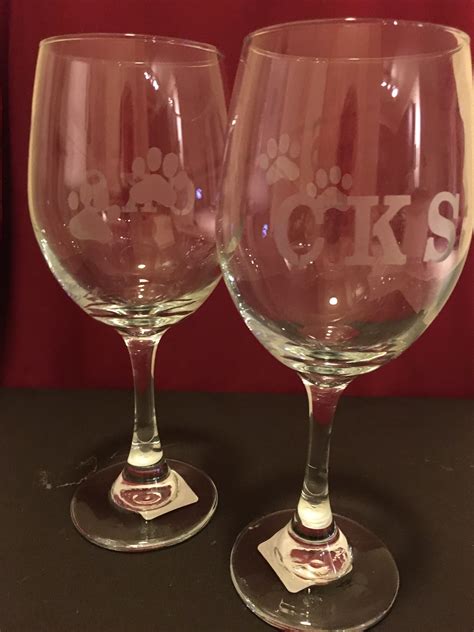 Two Wine Glasses Sitting Next To Each Other On A Table