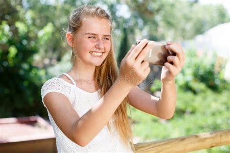 Portrait Of Teenage Cute Girl Making Photo With Smartphone At Sunny Day