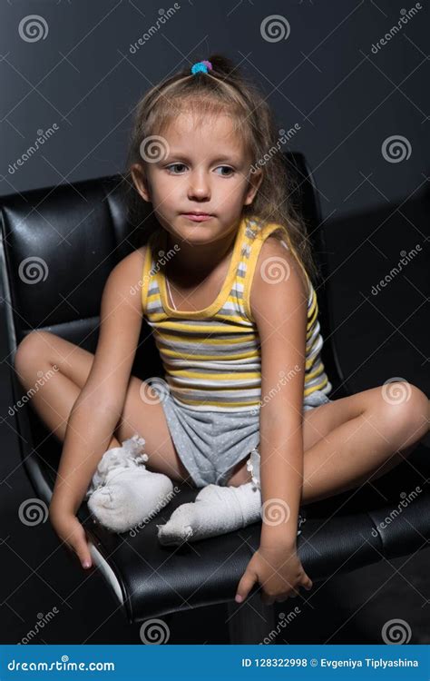 meisje vier jaar op een stoel stock foto image  slecht kleding