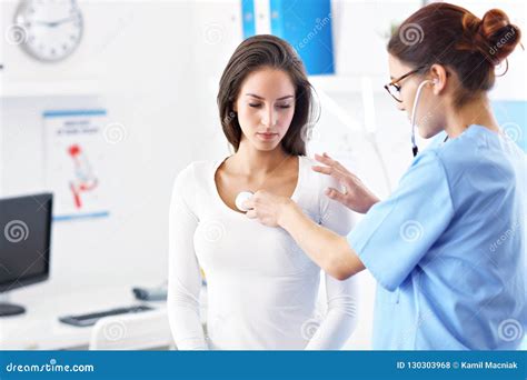 Adult Woman Being Examined With Stethoscope By Female Doctor Stock