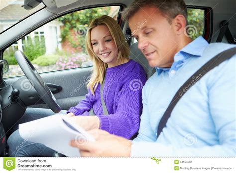 teenage girl having driving lesson with instructor stock