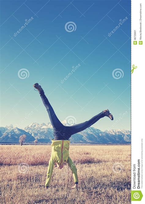 Color Toned Picture Of Young Woman Upside Down On A Meadow Stock Image