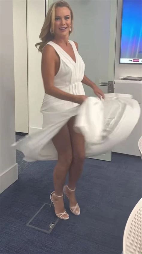 A Woman In A White Dress Posing For The Camera With Her Legs Spread
