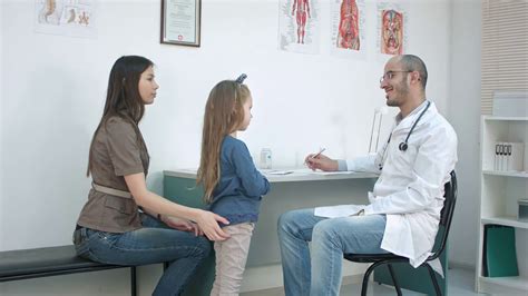mother with girl being examined by male pediatrician with stethoscope