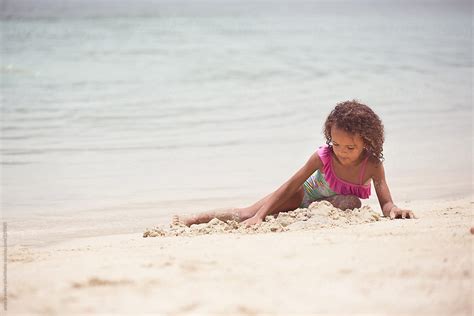 young girl lying   playing   sand  stocksy contributor