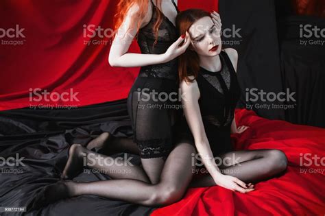 Two Redhaired Girl Hug On The Black And Red Background Two Lesbian
