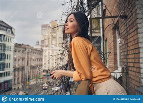Beautiful Lady Standing On Balcony And Looking At City
