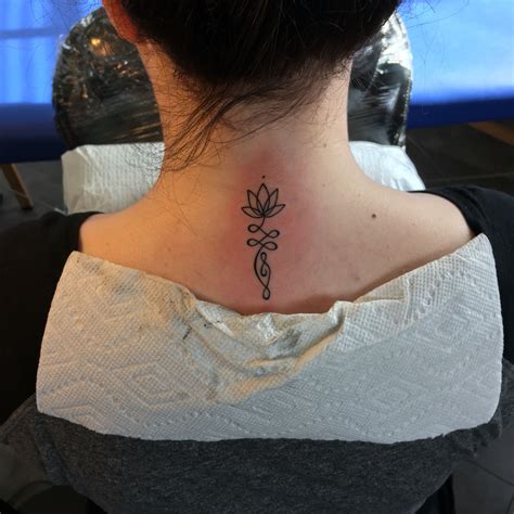 Lotus Flower Infinity Tattoo On The Back Of The Neck