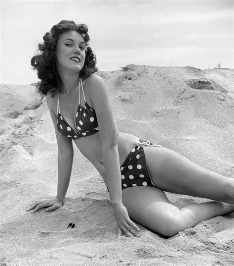 1950s 1960s Brunette Bathing Beauty Stretched Out On Sand Wearing Polka