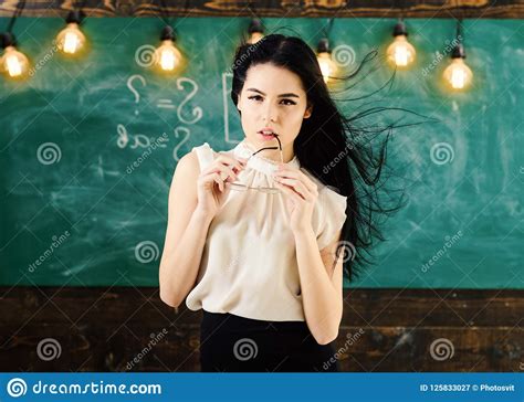 teacher with glasses and waving hair looks sexy woman