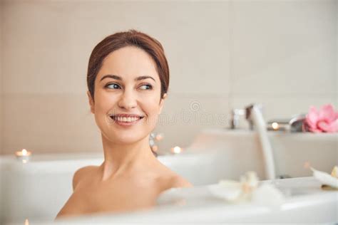Attractive Brunette Female Enjoying Taking Bath With Flowers Stock