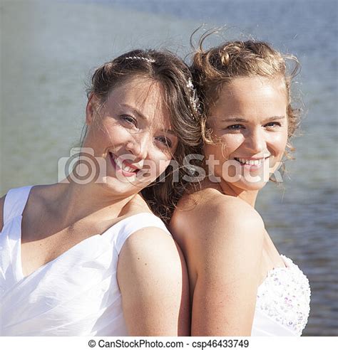 just married happy lesbian couple in white dress close together near