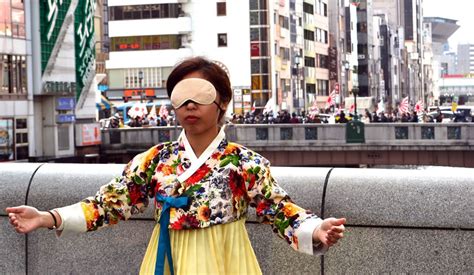 watch japanese nationalists march as blindfolded korean woman offers free hugs