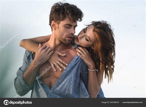 foco seletivo apaixonado jovem mulher tocando torso namorado contra céu