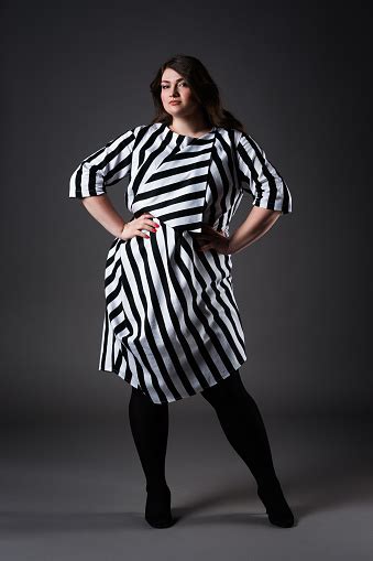 plus size fashion model in striped dress fat woman on gray background