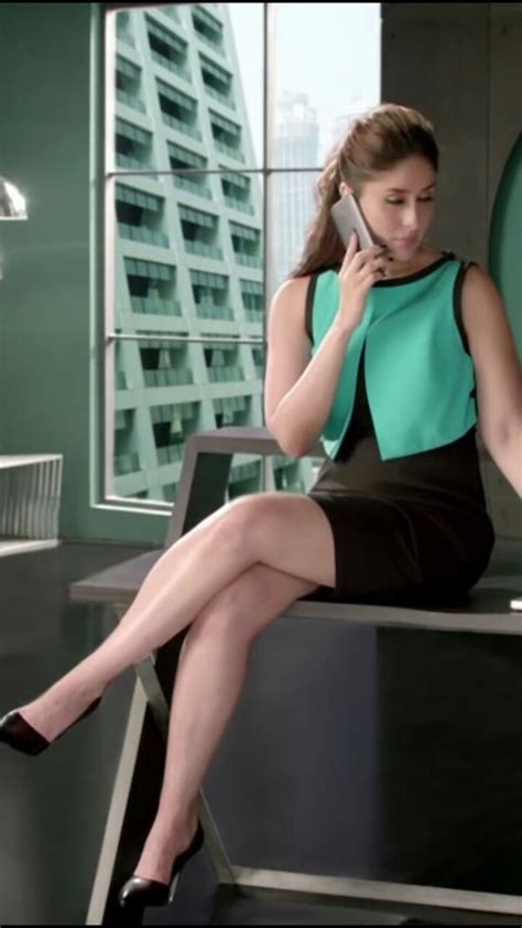 woman sitting   chair talking   cell phone  wearing  green  black dress