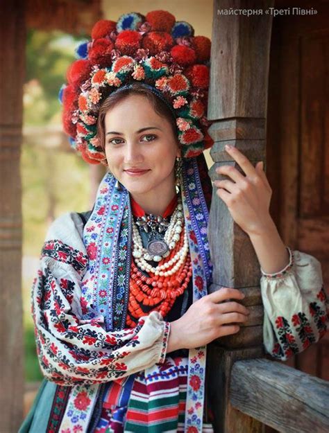 A Woman Wearing A Colorful Headdress Poses For A Photo With Her Hands