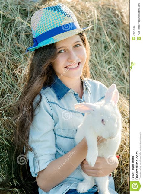 Cute Teen Girl With White Rabbit Sitting In Front Of