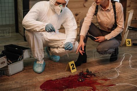 Cropped View Of Forensic Investigator And Female Detective Taking Notes