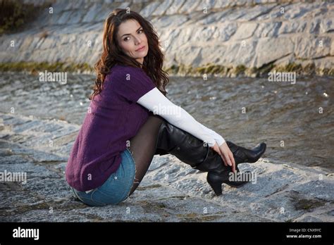 Brünette Junge Frau Posiert Sitzend In Einem Minirock Und Leder Stiefel