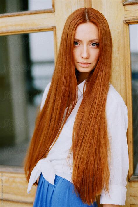 portrait of beautiful woman with long ginger hair by stocksy
