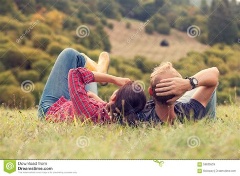 Couple Rest In Green Grass On The Hill In Country Side
