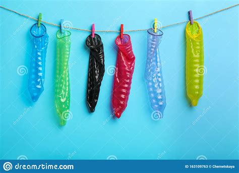 used colorful condoms hanging on clothesline against blue background safe sex concept stock