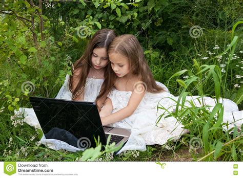 due bambine che parlano dietro un computer fotografia