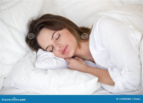 Calm Pretty Woman Sleeping Peacefully On White Sheets In Bed Stock