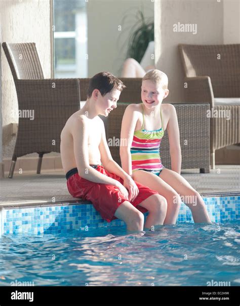 Ein Junge Und Ein Mädchen Von Einem Schwimmbad Im Haus Mit Sonne Saß