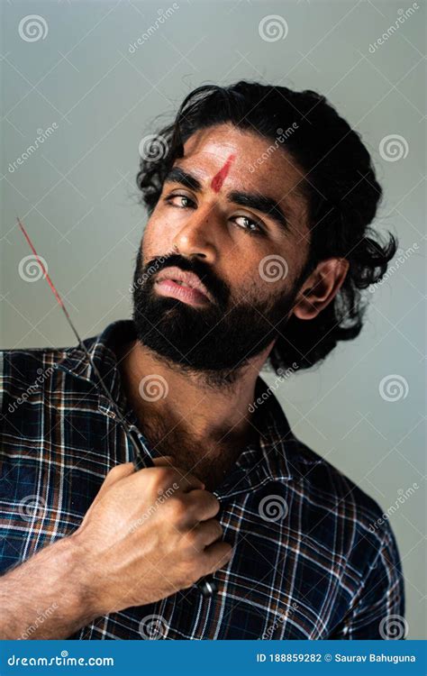 Indoor Portrait Of A Bearded Indian Male Wearing A Man Bun In