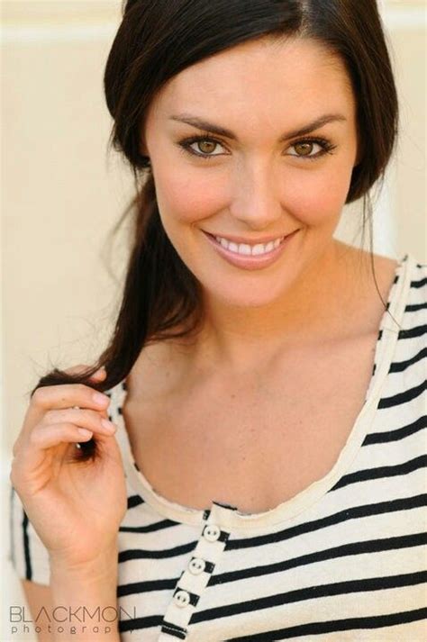 A Woman Smiling And Wearing A Black And White Striped Shirt With Her