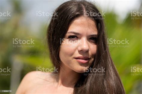 beautiful brunette enjoys the sun around the pool blurred background