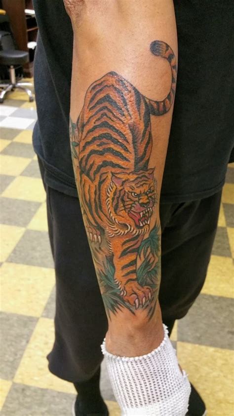 Wonderful Colorful Hunting Tiger Tattoo On Outer Forearm