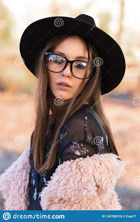beautiful brunette in fashion glasses and a shaggy coat