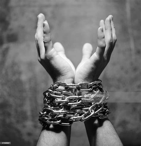 black and white closeup of wrists tied in chains photo getty images