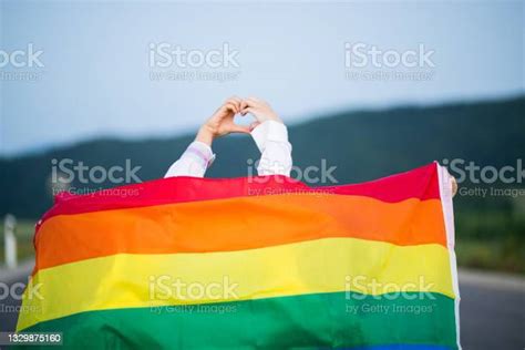 lesbijska para pokazująca serce simbol z rękami i noszenie tęczowej