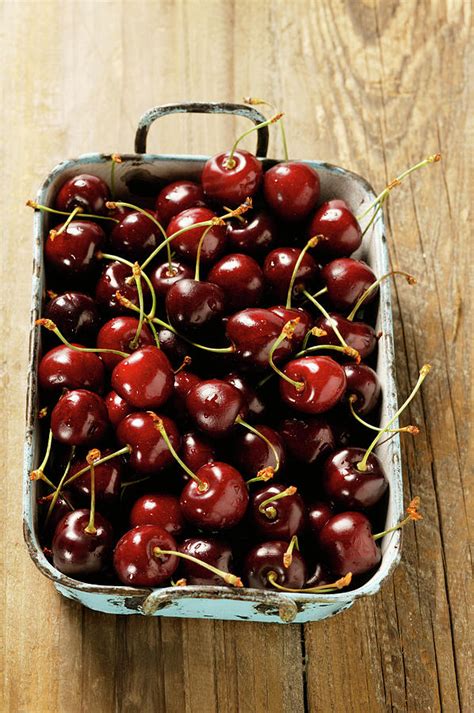 sweet black cherries in old roasting dish photograph by foodcollection