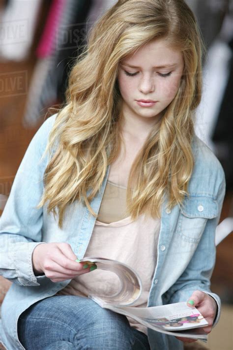 teenage girl with long blond hair and blue eyes reading a