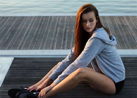 girl in gray hoodie sitting on the dock image free stock
