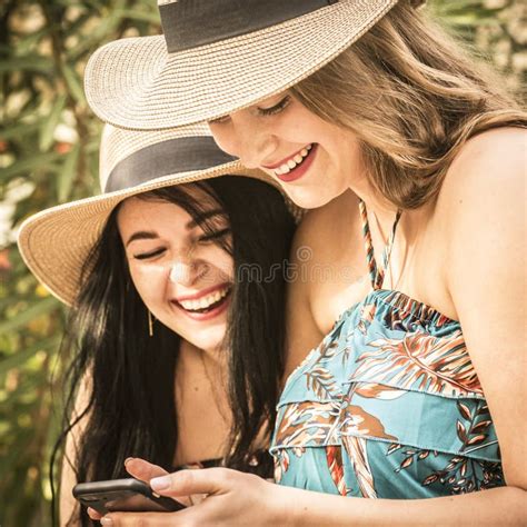 Couple Of Women Young Friends Have Fun Together Using Cellular Phone