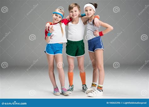 adorable smiling sporty kids  sportswear standing   grey stock photo image