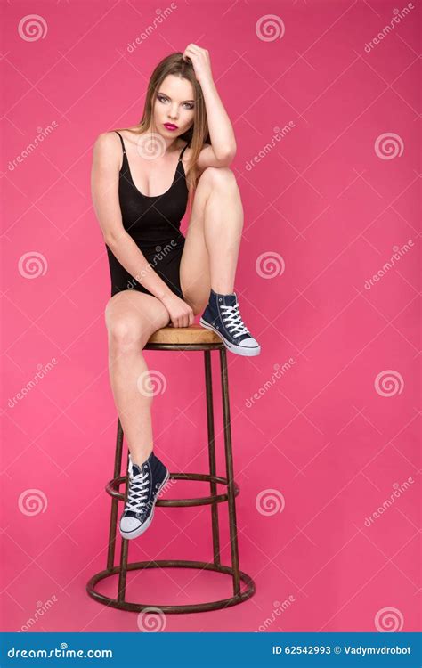 Full Length Portrait Of Pretty Girl Sitting On Bar Stool Stock Image