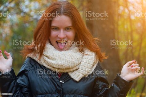 A Portrait Of A Redhaired Smiling Girl In A Jacket And Scarf Shows Her
