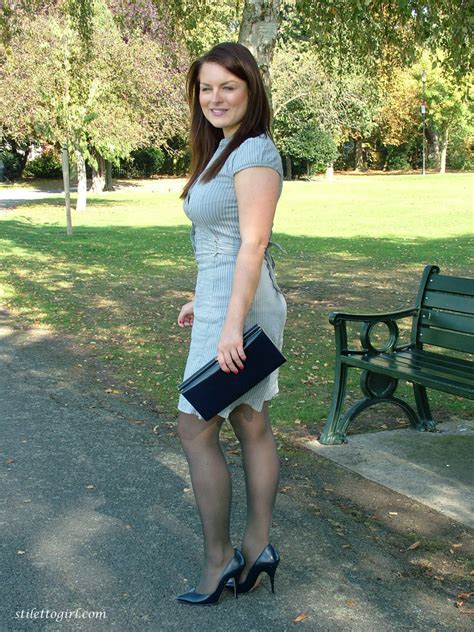 clothed woman shows off her nylon ensconced legs and pumps in the park