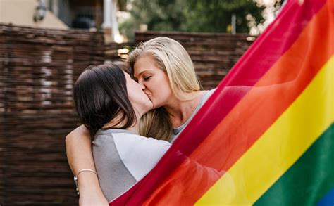 lgbt stolzes lesbisches paar küsst schwule regenbogenfahne stockfoto