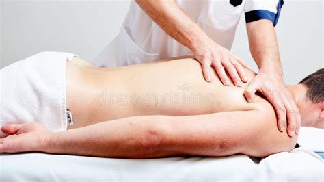 a massage therapist makes a man massage spa treatment health stock